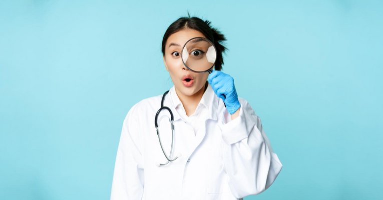 image-of-asian-woman-doctor-or-nurse-found-smth-looking-through-magnifying-glass-and-stare-surprised